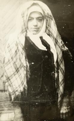 Older Woman Wearing a Headscarf and Sleeveless Jacket Against the Portal — unknown