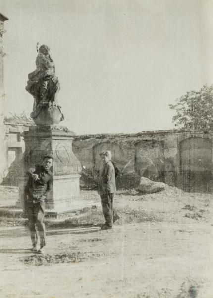 Men Next to a Sculpture of the Virgin Mary on the Territory of the Capuchin Monastery