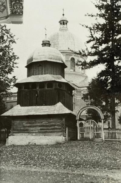 Wooden Bell Tower Next to a Stone Church